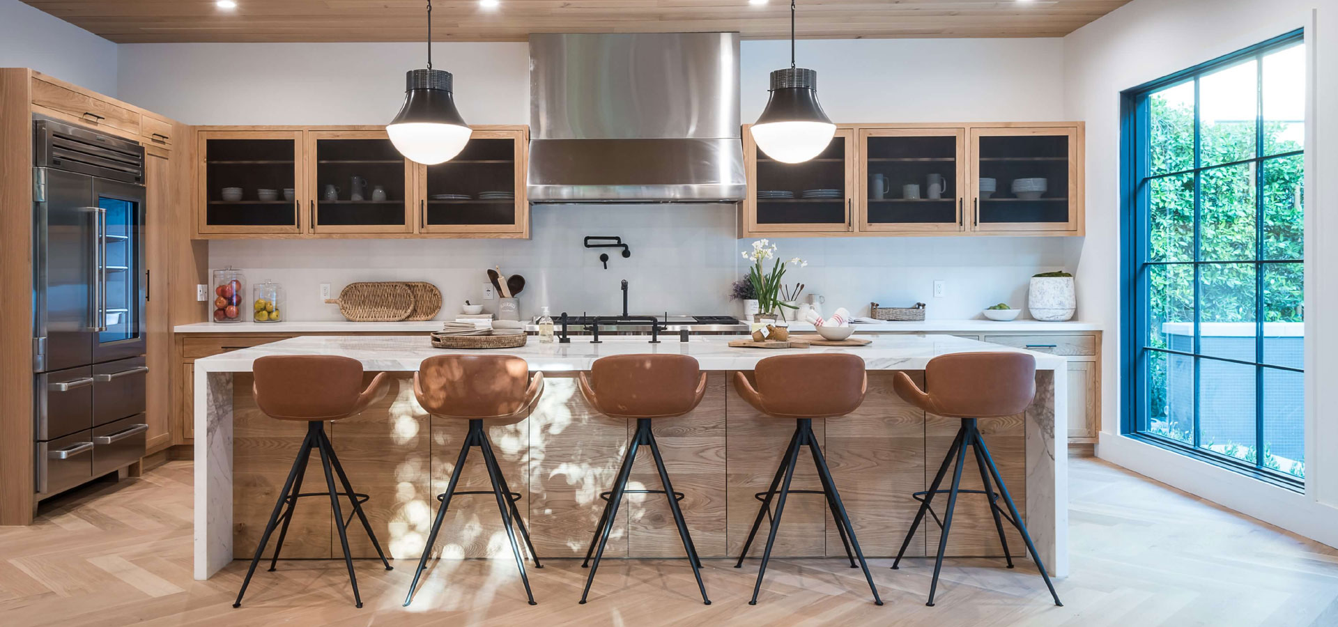 A kitchen with several stools and lights in it.
